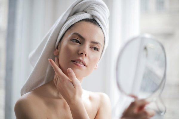 Woman examining skin for treatment results